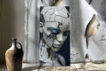 Fractured porcelain humanoid face in slate blue and off-white, moody digital portrait canvas art for living room