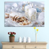 O natură moartă festivă care prezintă o lumânare aprinsă înconjurată de produse de patiserie de Crăciun și decorațiuni sezoniere în tonuri