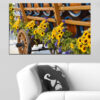 A weathered wooden wagon sits loaded with sunflowers, their yellow petals bright against green foliage and aged wood