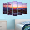 A symmetrical mountain peak rises at the center, framed by warm sunrise tones transitioning from deep orange to soft blue