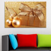 A red gift box wrapped with a gold ribbon sits against a warm bokeh background of golden lights