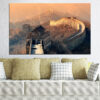A stone watchtower stands on the Great Wall of China, set against blue sky and layered mountain ridges
