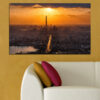 A sunrise glows above an urban skyline, with warm tones spreading across the sky