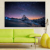 A mountain peak rises beneath a starry sky filled with cosmic clouds