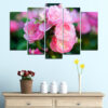 Five blooming roses in shades of pink and cream, captured in natural light with soft green foliage