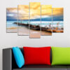 Five canvas panels showing seabirds resting on dark coastal rocks with ocean waves rolling in under a soft blue sky