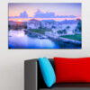 A sunset scene over calm river water, dominated by warm orange and pink tones in the sky