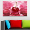 A single red cherry sits against a black background, surface covered in water droplets that catch the light