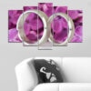 Two gold wedding rings rest on soft lilac blossoms, surrounded by white and pale purple petals