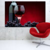 A red wine bottle and glass set against a dark background