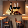 A wine bottle, cheese wedge, and glass arranged on a dark surface